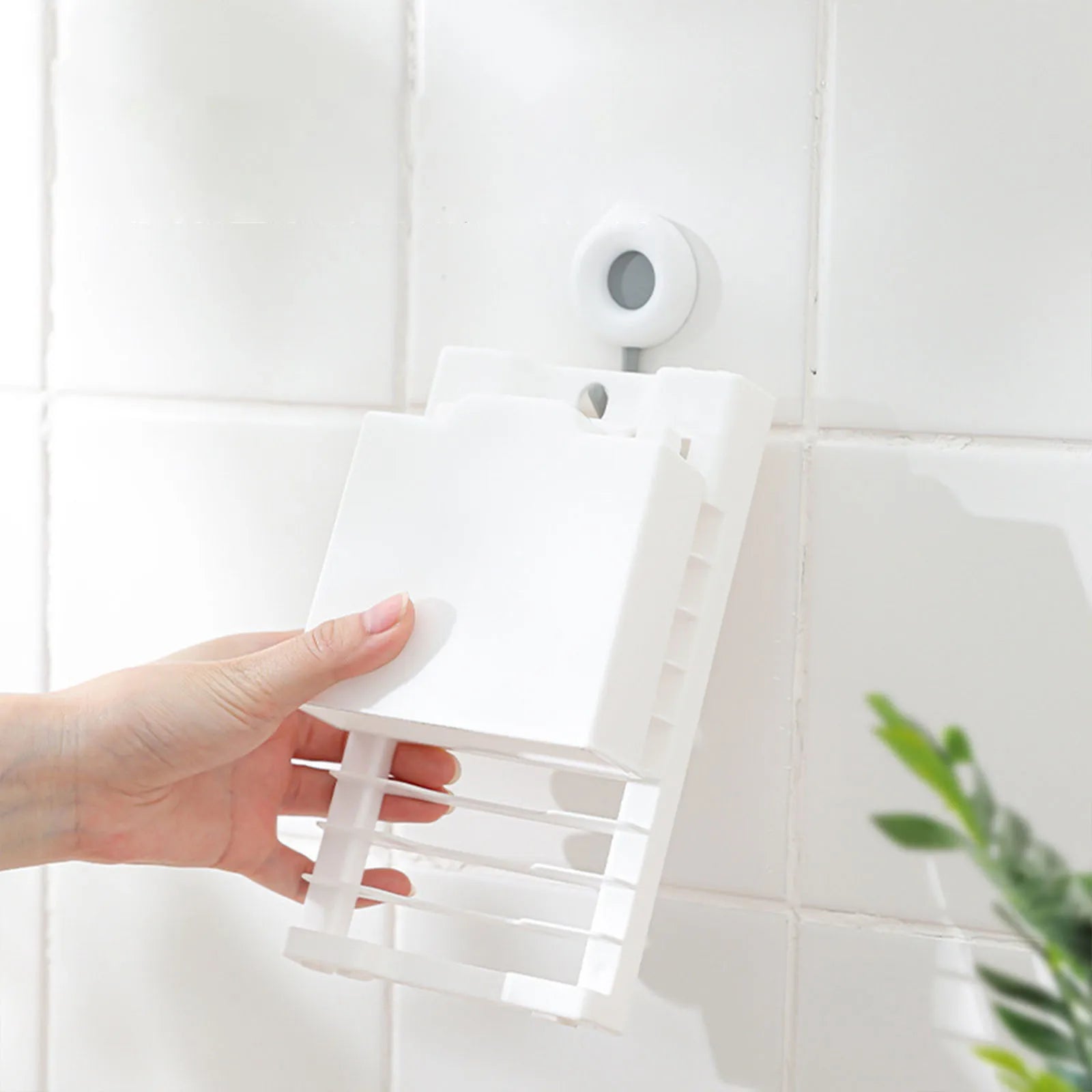 White dish drying rack being hung on a wall hook for storage