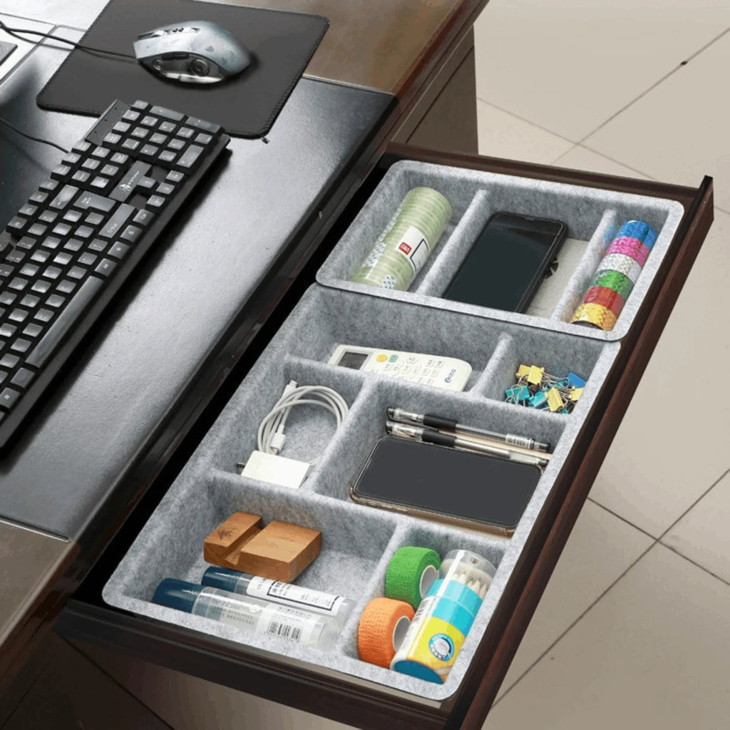 Office drawer with two felt organizer trays neatly storing pens, phone, chargers, and office supplies
