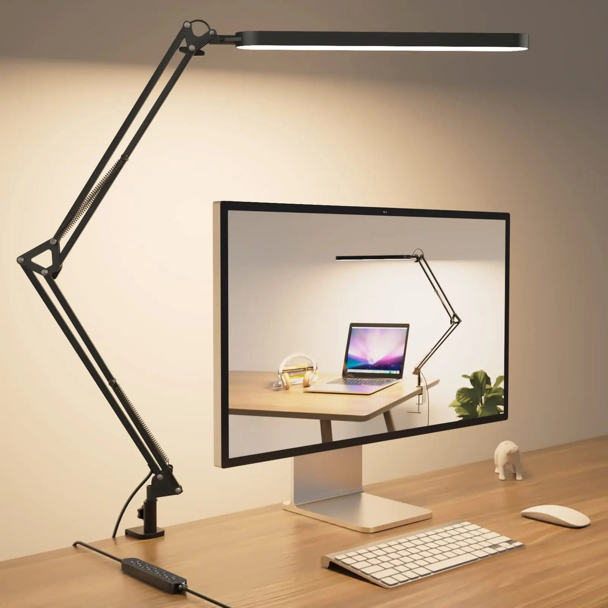 Adjustable clamp arm LED desk lamp in black mounted on wooden desk beside computer monitor