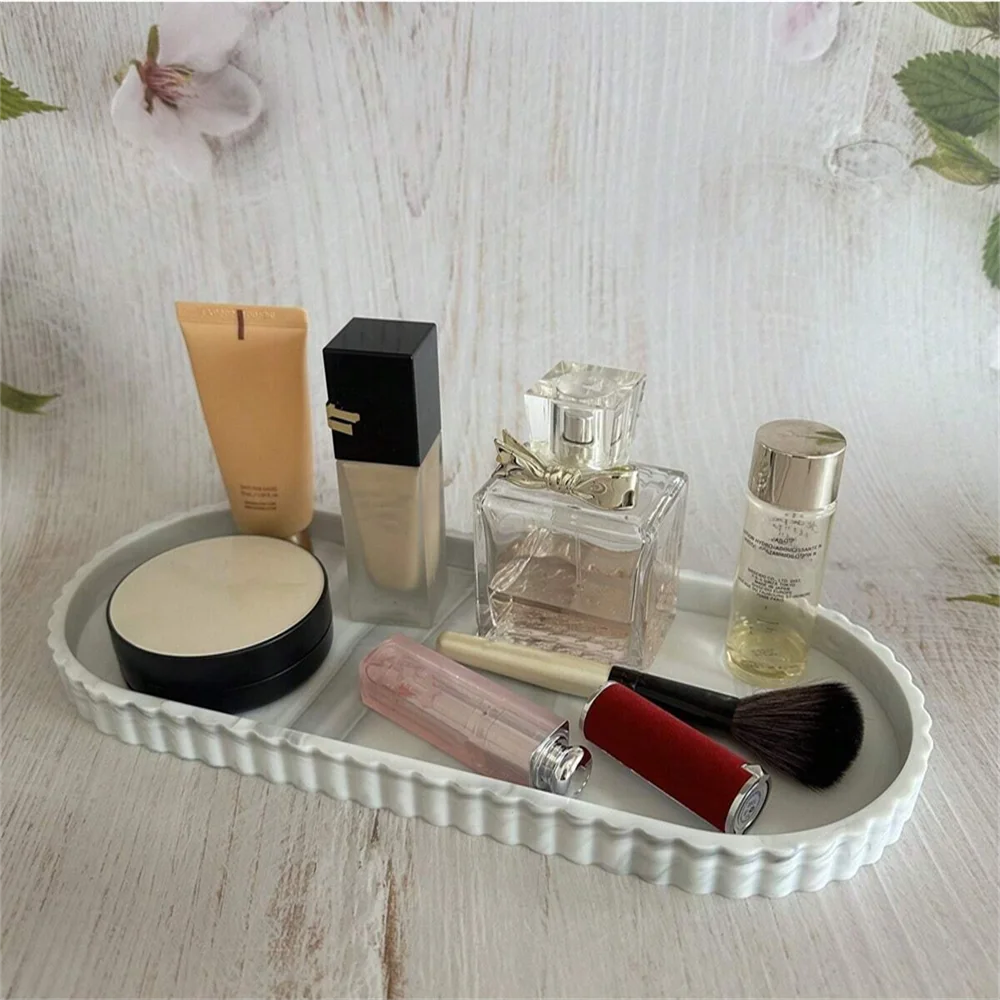 White scalloped silicone tray used to hold makeup and perfume on a vanity