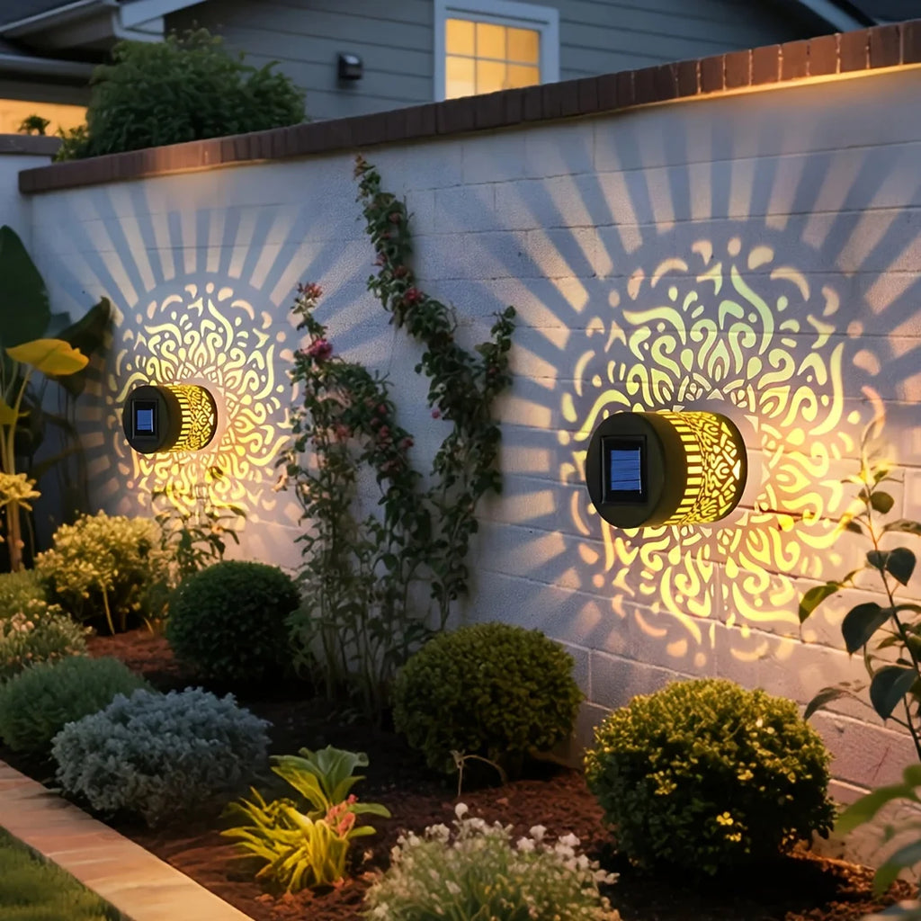 Solar mandala wall lanterns illuminating a garden fence with patterned light
