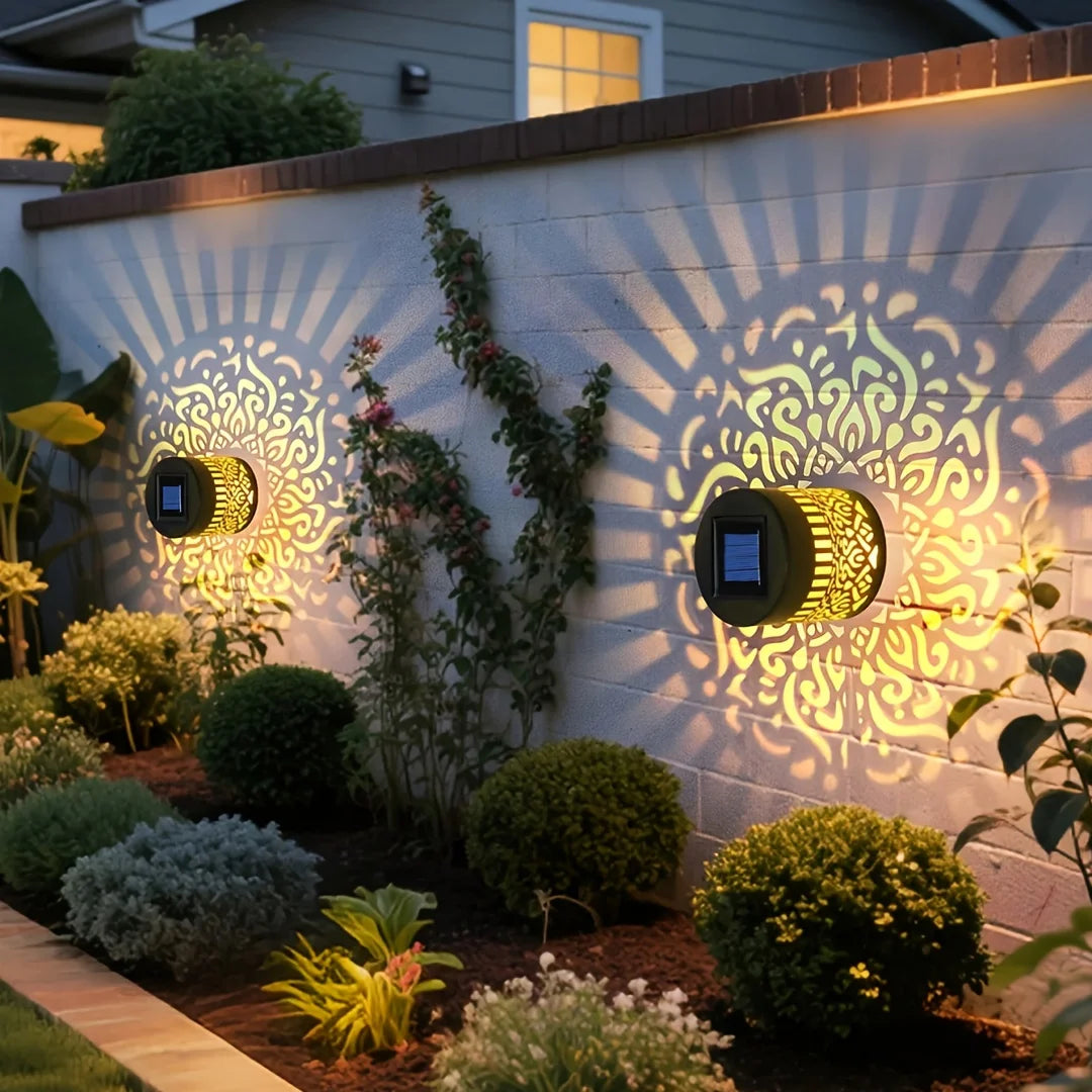Solar mandala wall lanterns illuminating a garden fence with patterned light