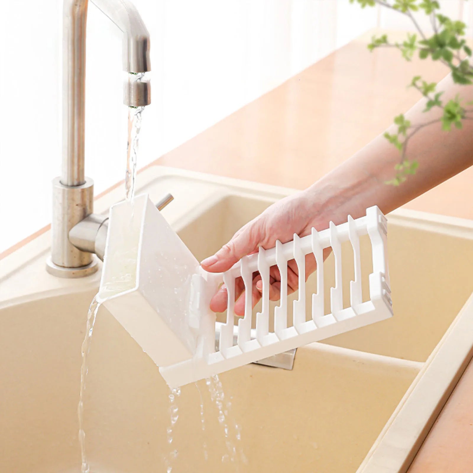 Dish drying rack being rinsed with water under a kitchen faucet
