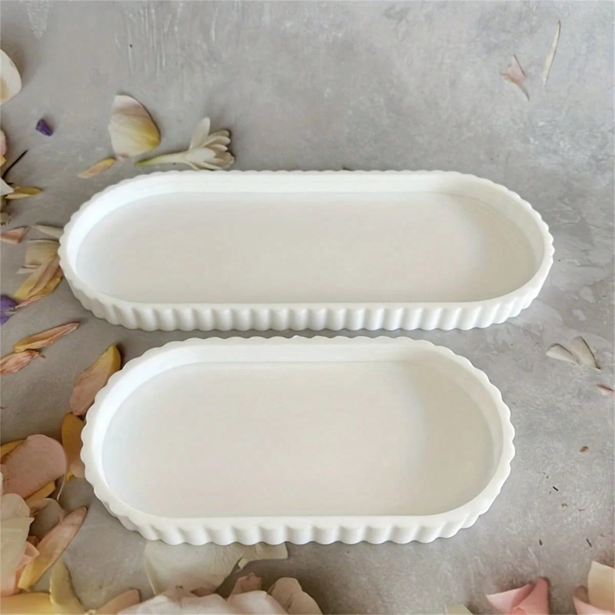 Two white scalloped-edge silicone trays on a neutral background