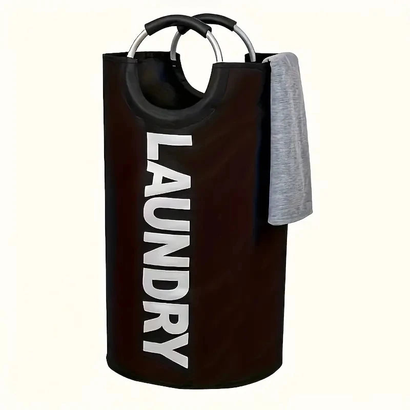 Black foldable laundry hamper with soft handles and gray towel over the side