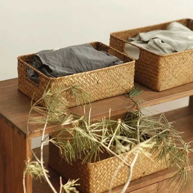 Rectangular woven seagrass storage baskets with linens on wooden shelves