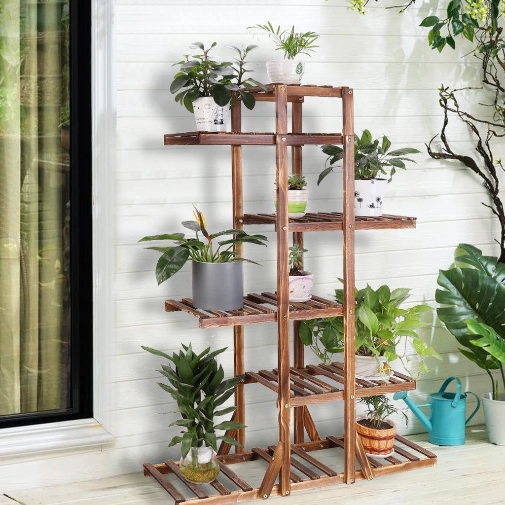 Slatted wooden plant stand with six tiers displayed on a patio, holding assorted potted plants