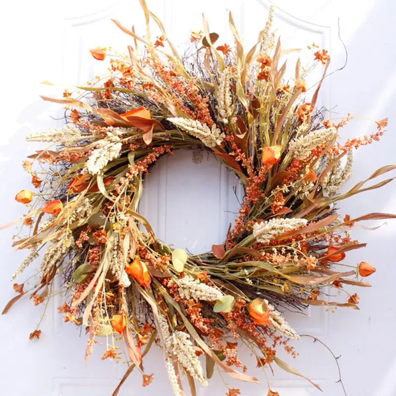 Artificial fall wheat ears wreath with orange and golden foliage hanging on a white front door