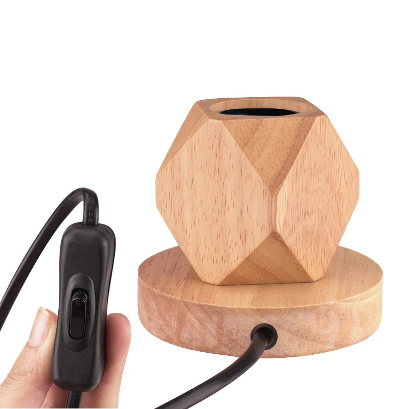 Faceted wood table lamp base with power switch in hand