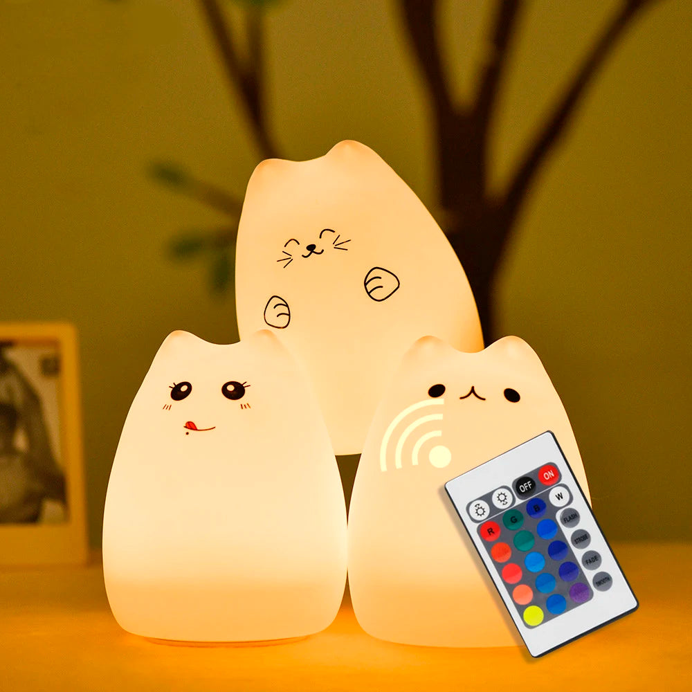 three silicone cat night lights with different facial designs and one remote control