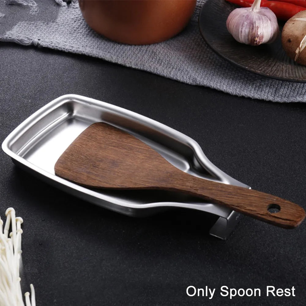 Spoon rest holding a wooden spatula, next to garlic and vegetables on a textured surface