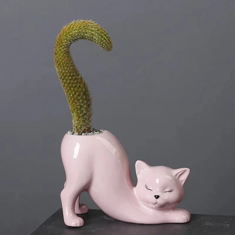 Single pink cat-shaped ceramic succulent planter with cactus, on a gray surface