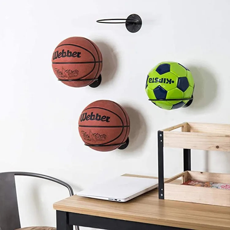 Desk area with basketball, soccer ball, and another basketball organized on wall-mounted racks
