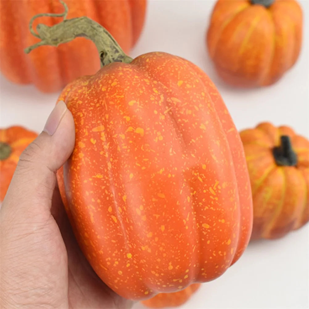 Close-up of an orange artificial pumpkin being held to show surface detail and realistic stem