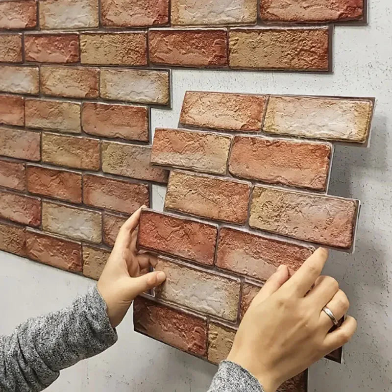 Hands installing a 3D brick-pattern self-adhesive wall panel on a white wall