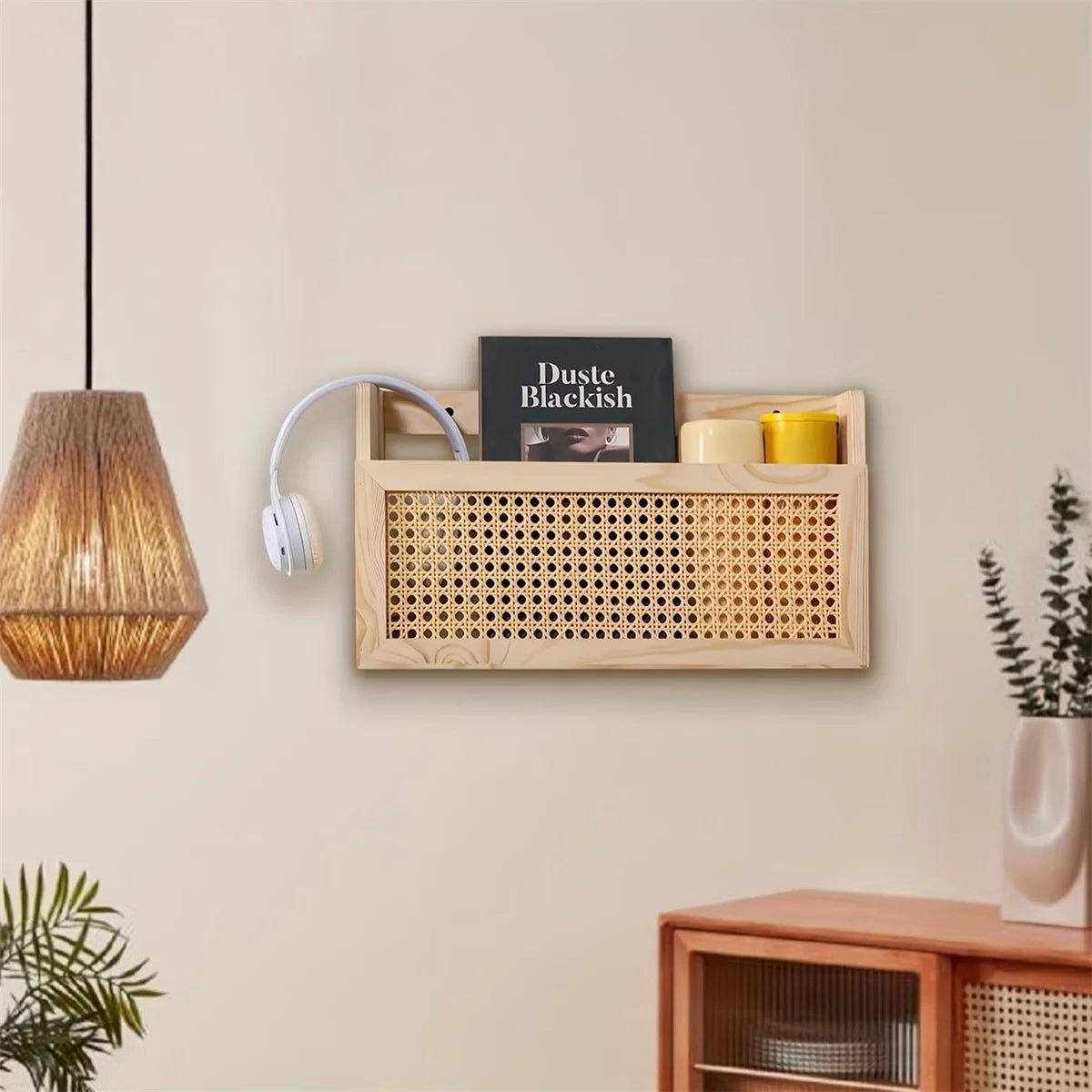 Living room setting with wall-mounted wooden magazine organizer and rattan front, next to a pendant lamp