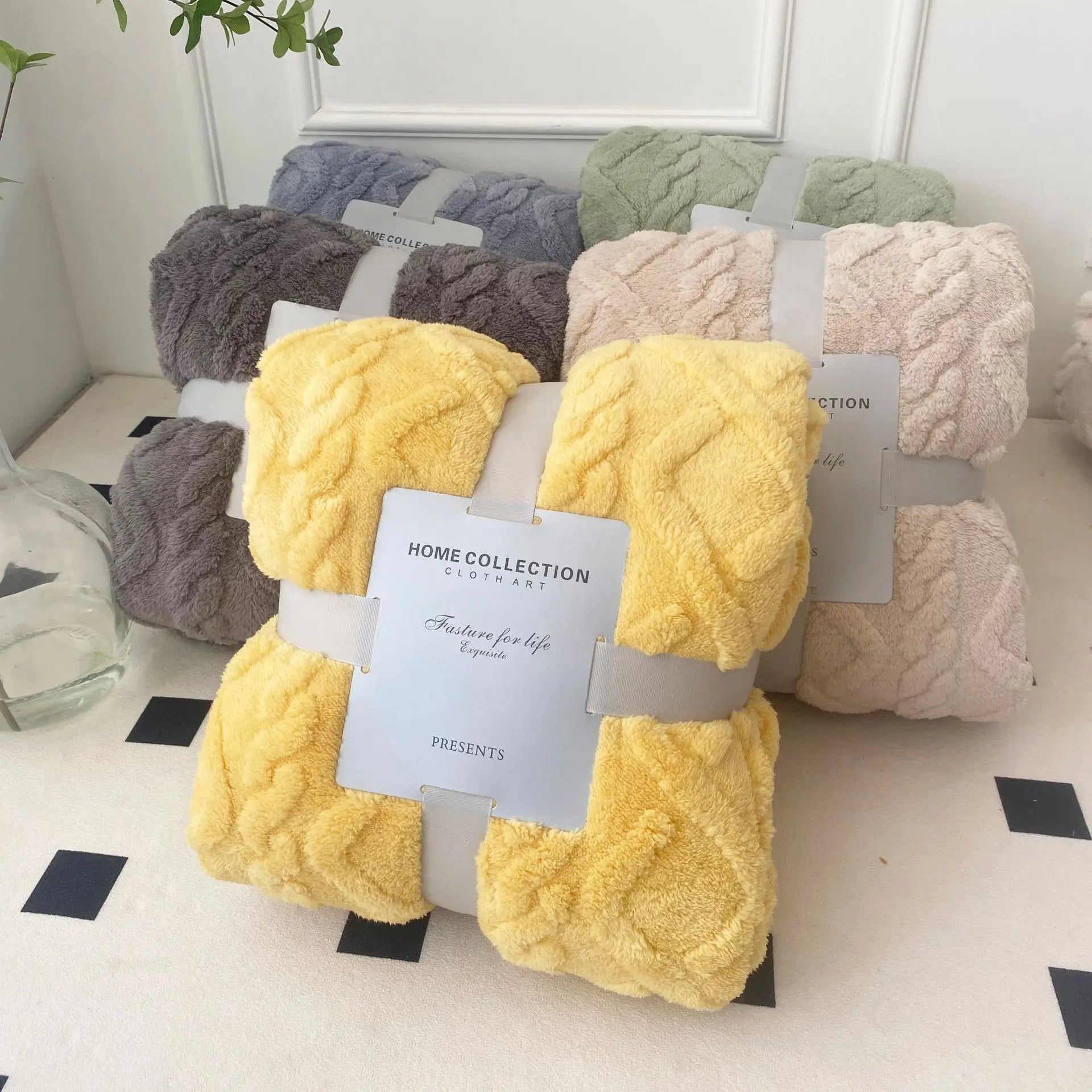 Assorted colors of braided sherpa fleece throw blankets bundled, including grey, green, beige, yellow, and brown