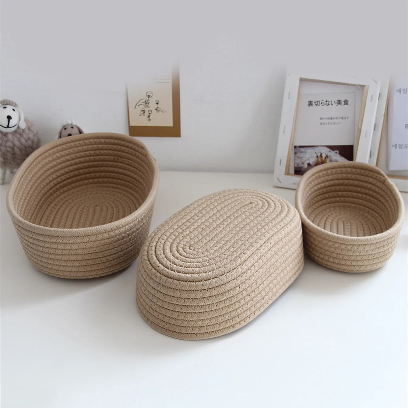 Three khaki cotton rope baskets showing bottom and side, arranged on a desk