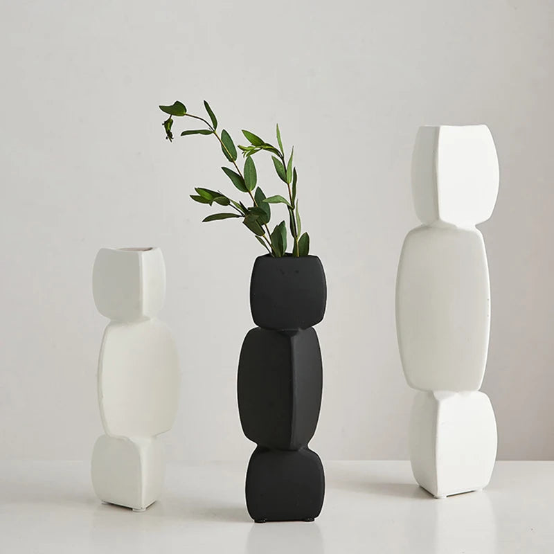 Three modern black and white ceramic vases displayed together, minimalist decor style