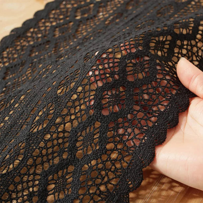 Close-up of black crochet lace table runner's woven pattern and scalloped edge