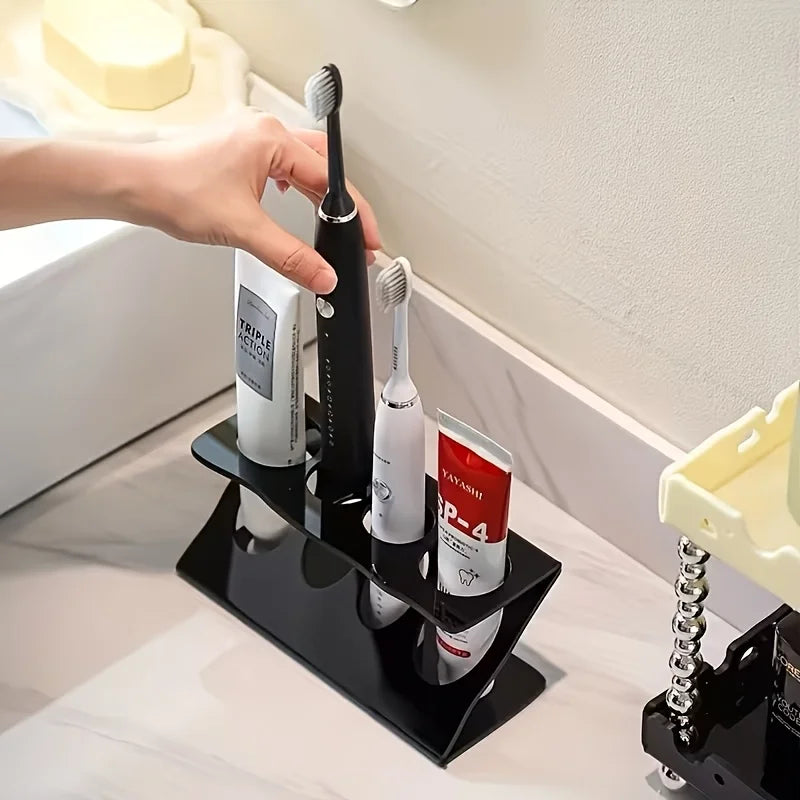 Person placing a toothbrush in black stand next to other brushes and toothpaste in bathroom
