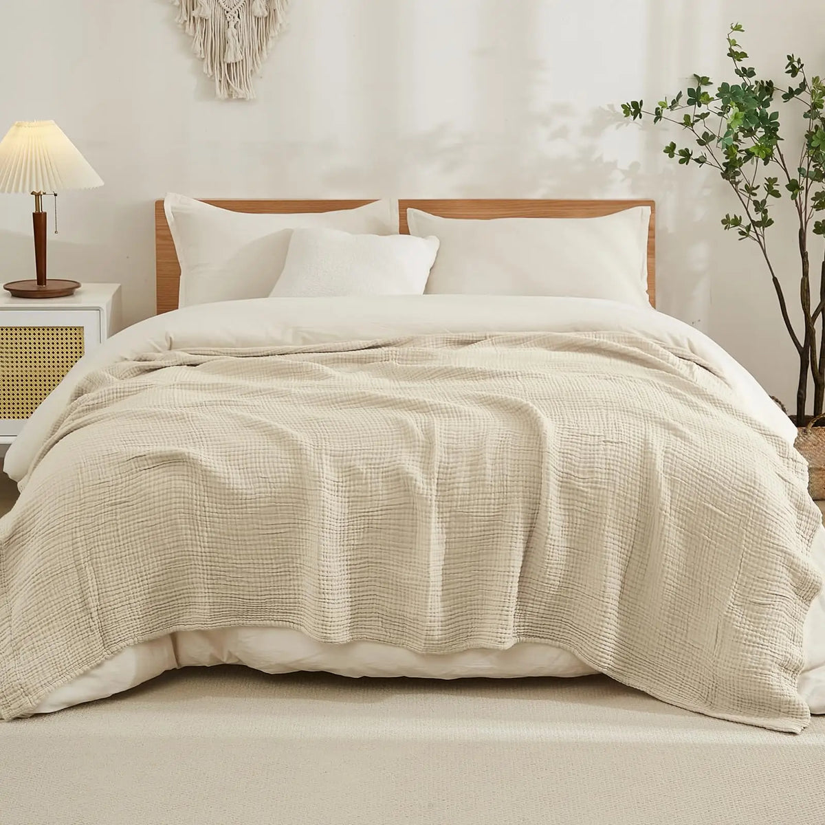 beige cotton muslin blanket on a made bed in a neutral bedroom
