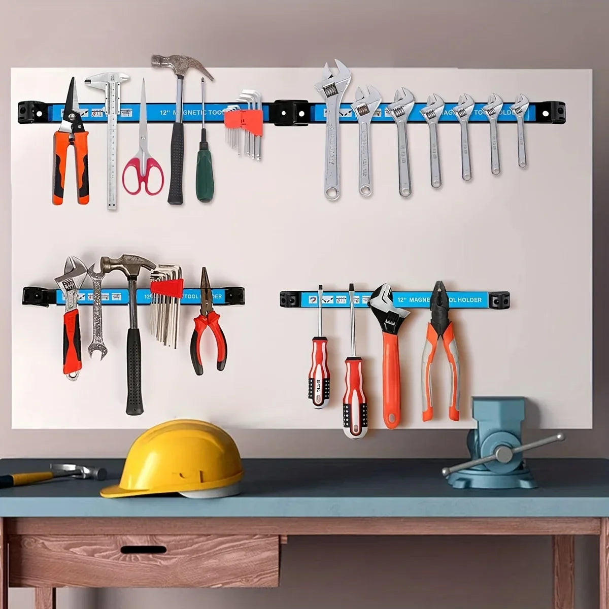 Magnetic tool holder bars mounted on a wall holding a variety of tools including hammers, pliers, scissors, and screwdrivers in a workshop or garage setting