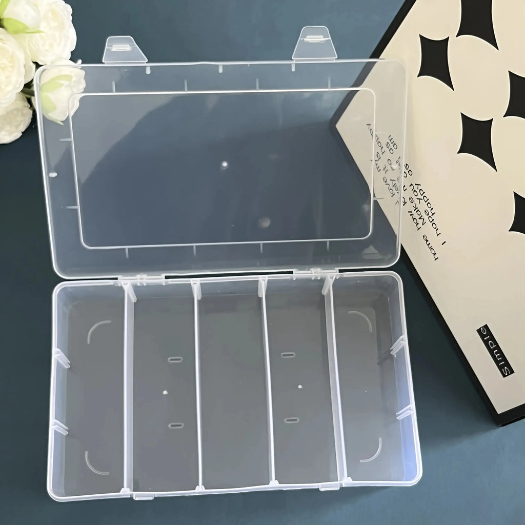 Top-down view of empty clear 5-compartment organizer box with open lid