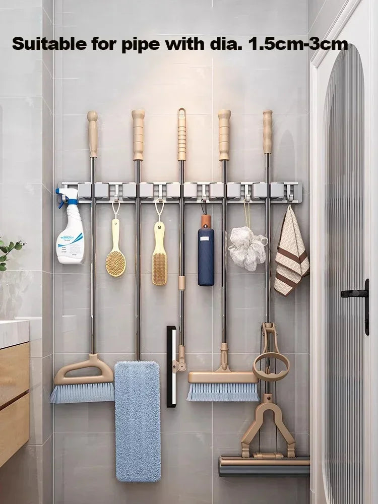 Wall-mounted broom and mop organizer holding multiple handled tools and cleaning cloths