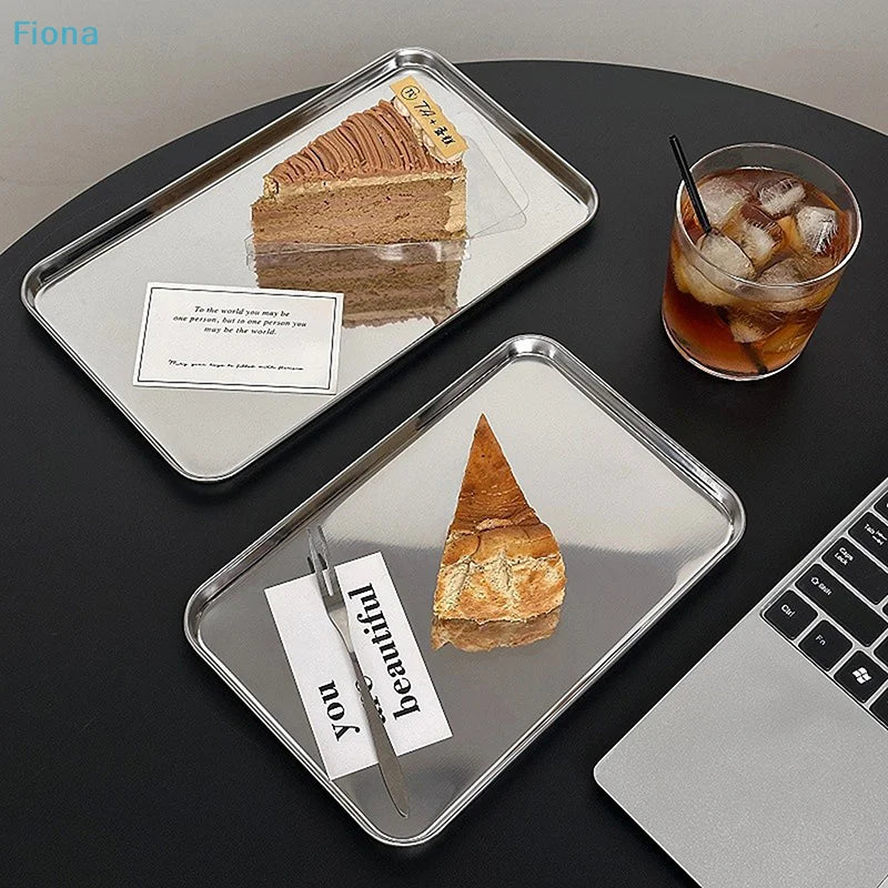 Two stainless steel serving trays on a dark tabletop with cake slices and drinks