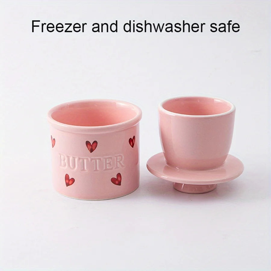 Pink ceramic French butter crock separated into its two main pieces, labeled as freezer and dishwasher safe.