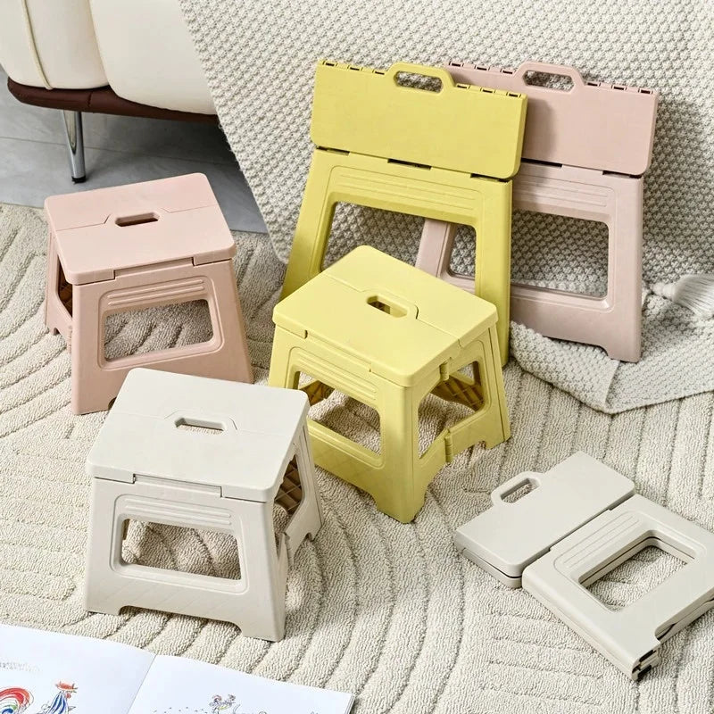 Assortment of folded and open pastel folding step stools on a textured rug in a living area