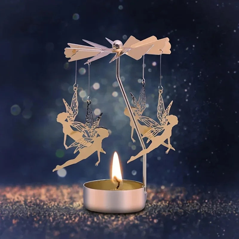 Spinning fairy motif tealight candle holder in gold, shown with a candle glowing in a dark background