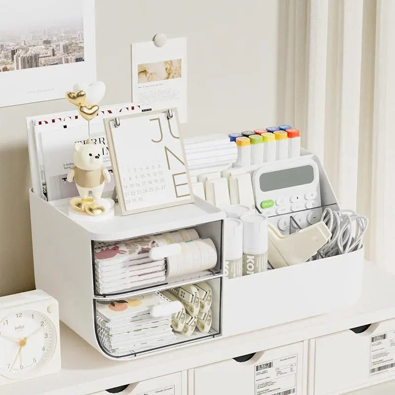 White desktop storage rack with drawers, filled with notebooks, markers, and calendar, on a study table