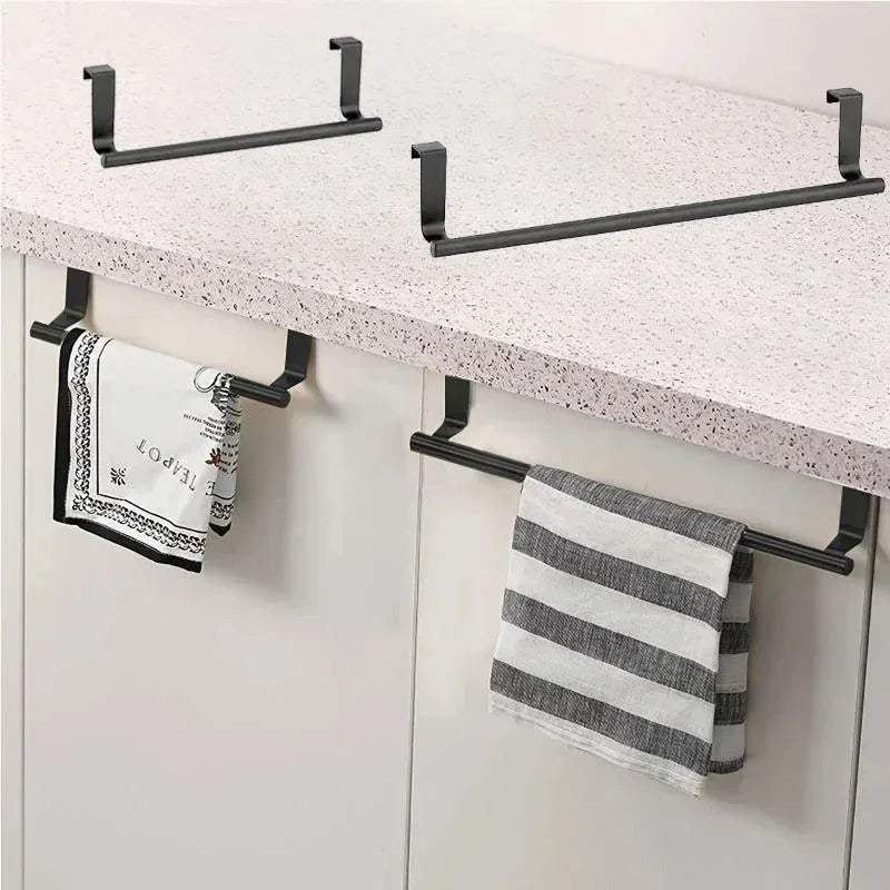 Black over-cabinet towel racks installed on white kitchen cabinet doors holding dish towels