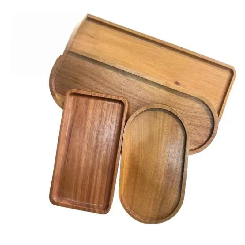 Two rectangular and one oval acacia wood trays shown overlapping on a white background