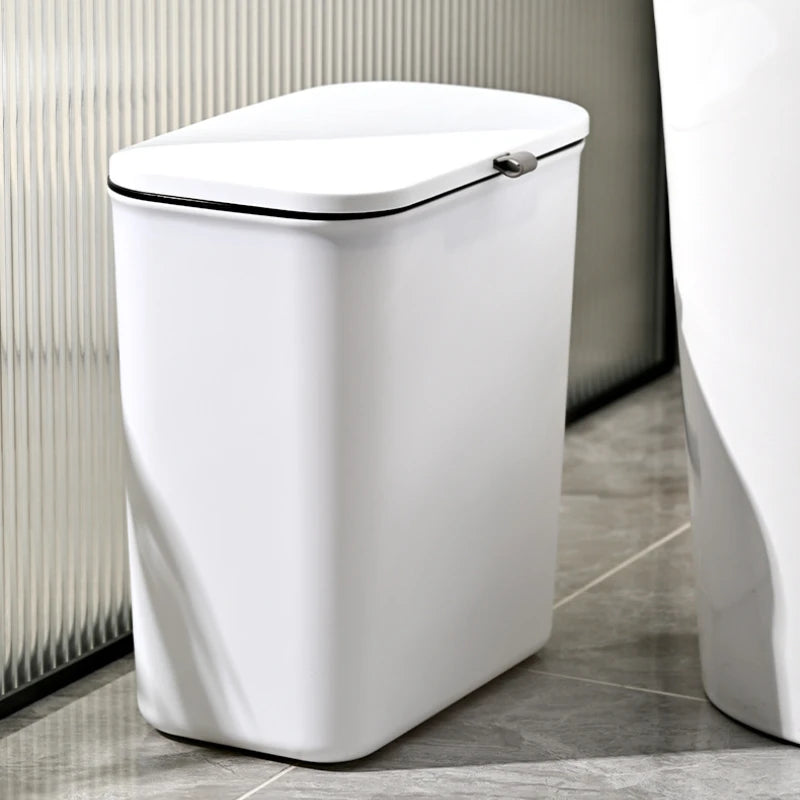 white rectangular trash bin placed on floor beside bathroom fixtures
