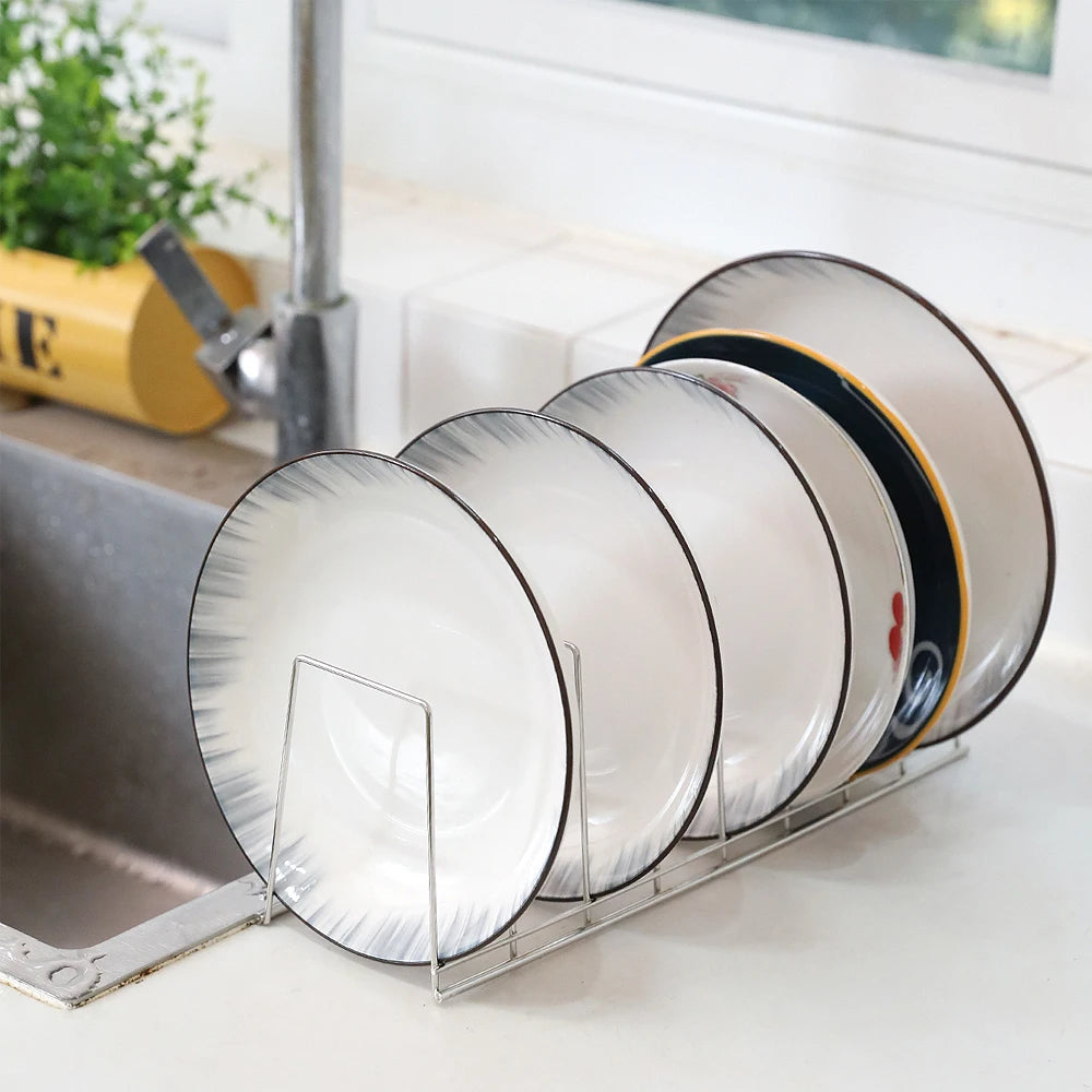 stainless steel dish rack holding ceramic plates by a kitchen sink