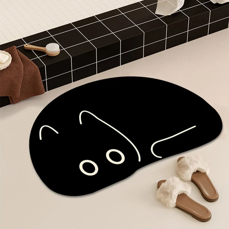 Black cat-shaped quick-drying bath mat beside a bathtub, with slippers.