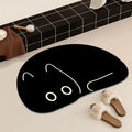 Black cat-shaped quick-drying bath mat beside a bathtub, with slippers.
