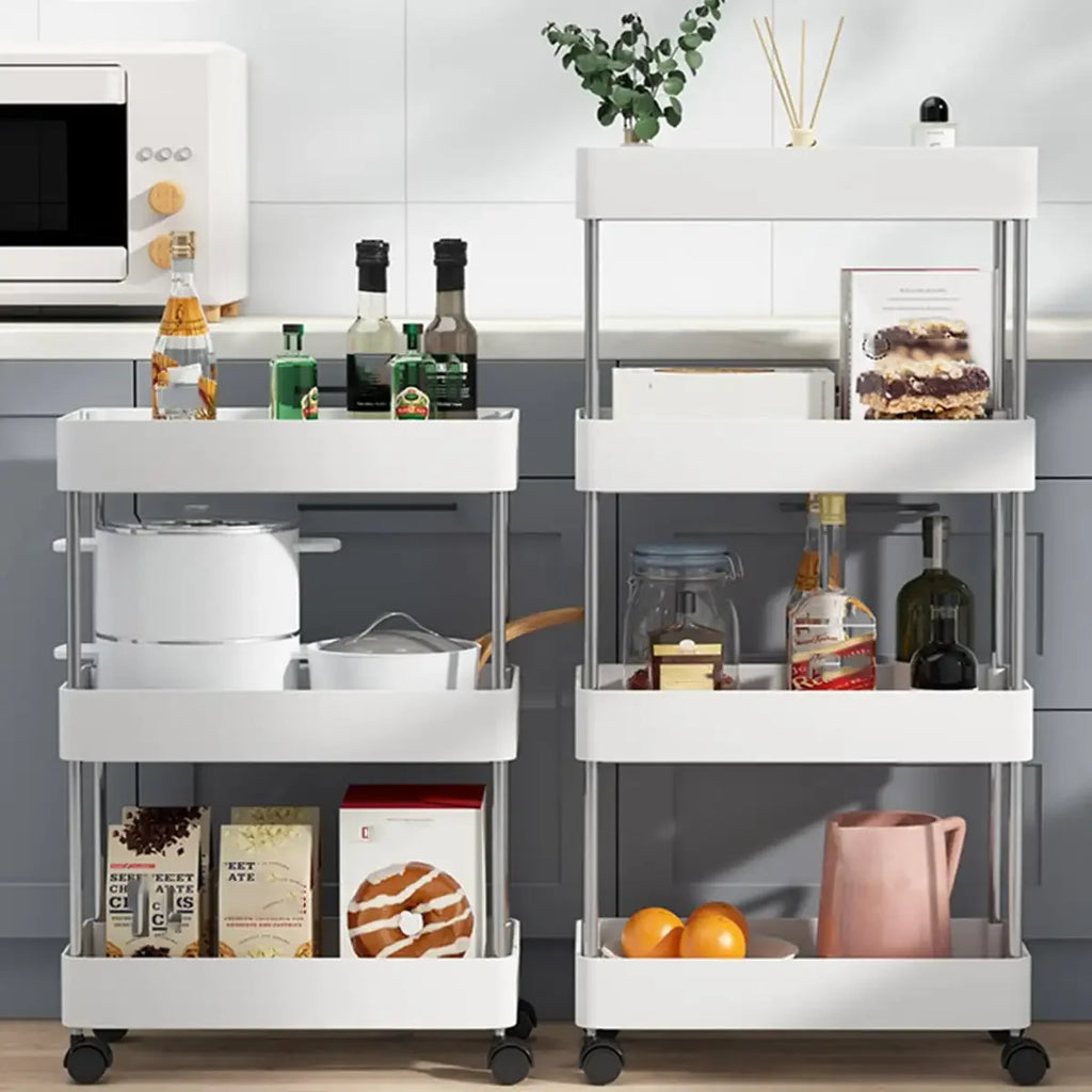 Two white slim rolling carts holding pantry items and bottles in a modern kitchen setting