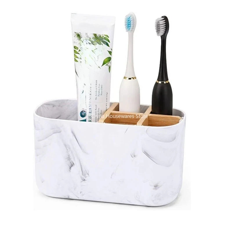Marble finish divided toothbrush holder with bamboo dividers holding two toothbrushes and a toothpaste tube on a plain background