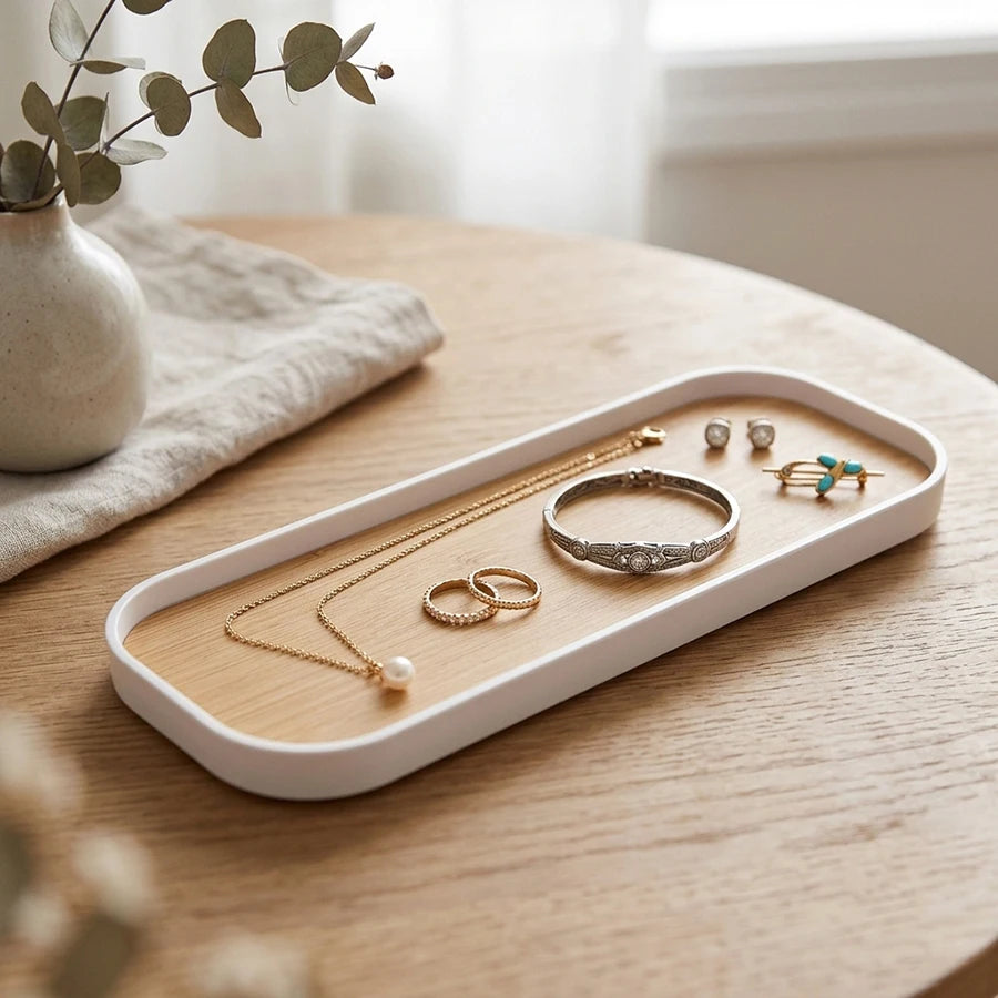 White rim vanity tray used for jewelry storage on a wooden tabletop