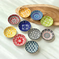 Set of 10 round ceramic dishes in assorted mandala and boho patterns arranged on a table
