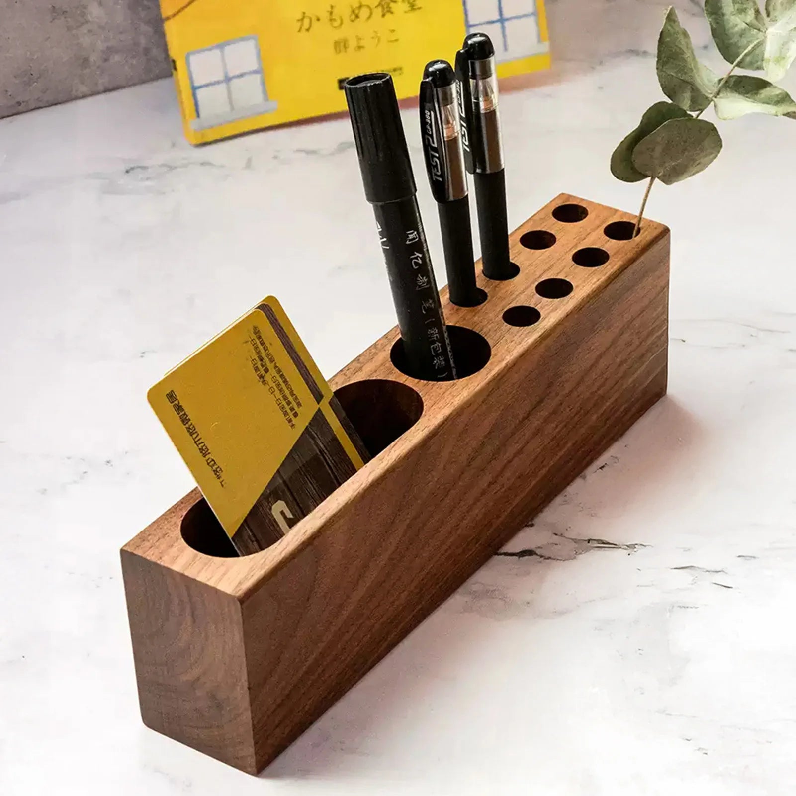 angled view of wooden pen and card holder with pens and cards inside