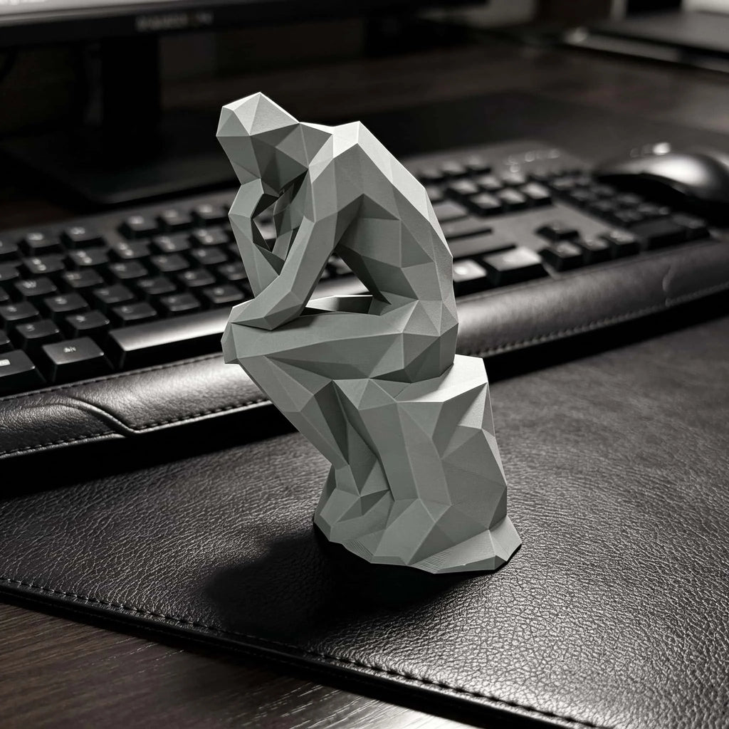 Matte plastic geometric figurine placed on a dark desk in a modern workspace