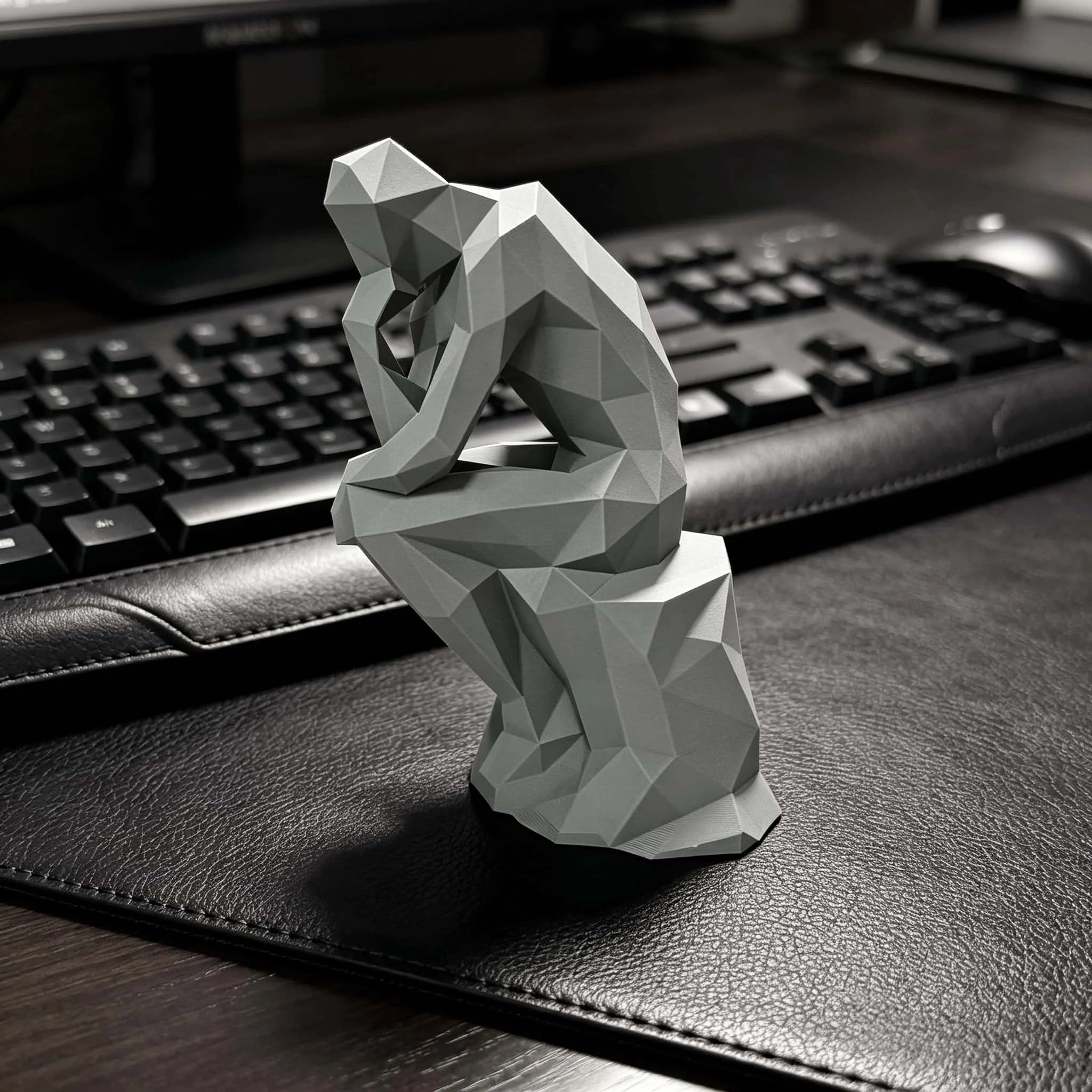 Matte plastic geometric figurine placed on a dark desk in a modern workspace