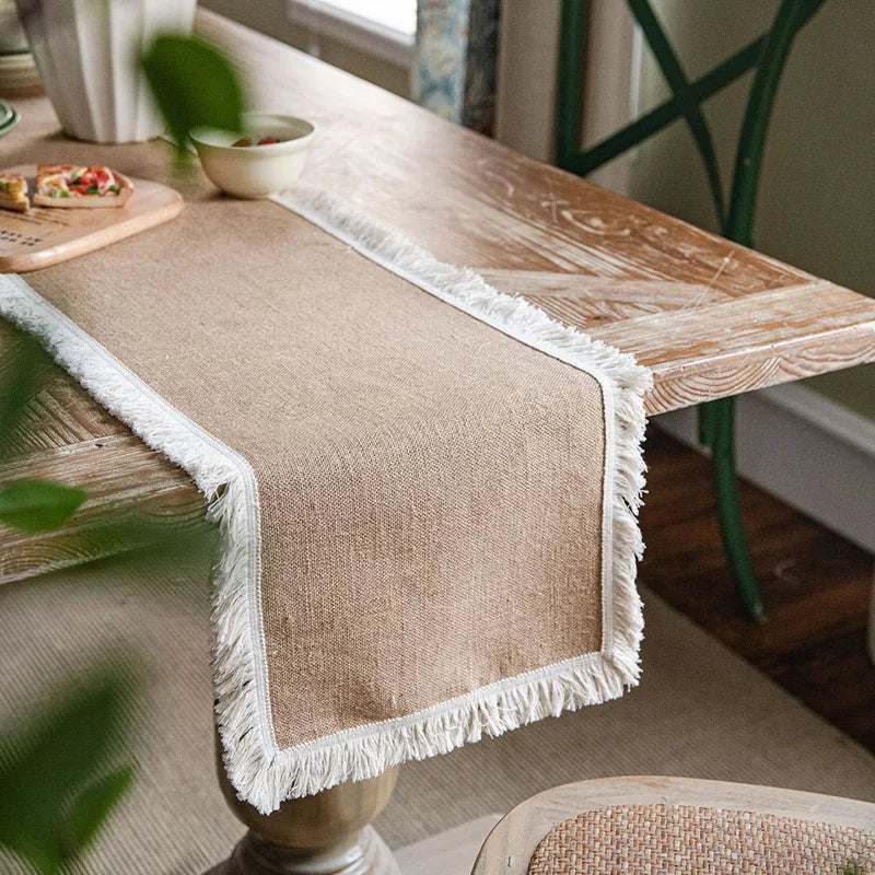 Farmhouse jute table runner with white fringe edge on a cozy kitchen table