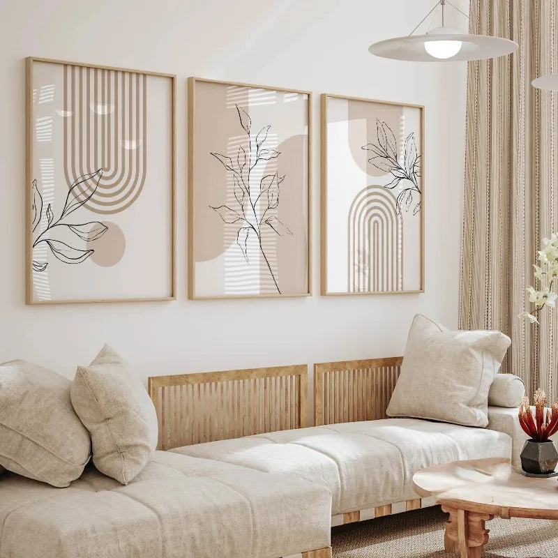 Modern living room with neutral canvas botanical art in natural wood frames above a light upholstered bench