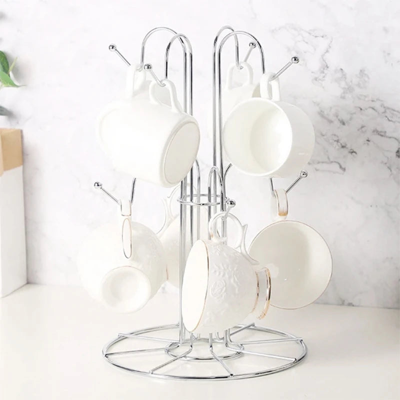 Tree-shaped metal mug holder on a kitchen counter with 6 white mugs hanging